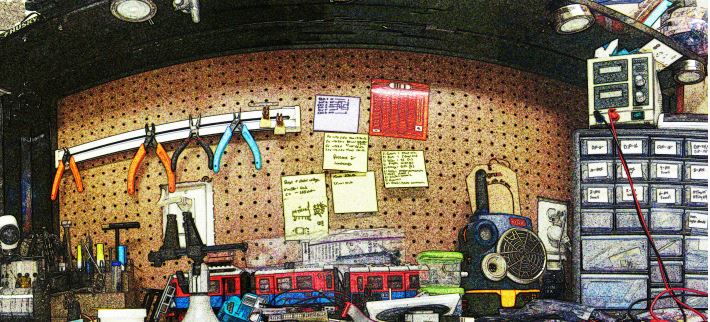 a work-bench with bins of parts and tools on peg board